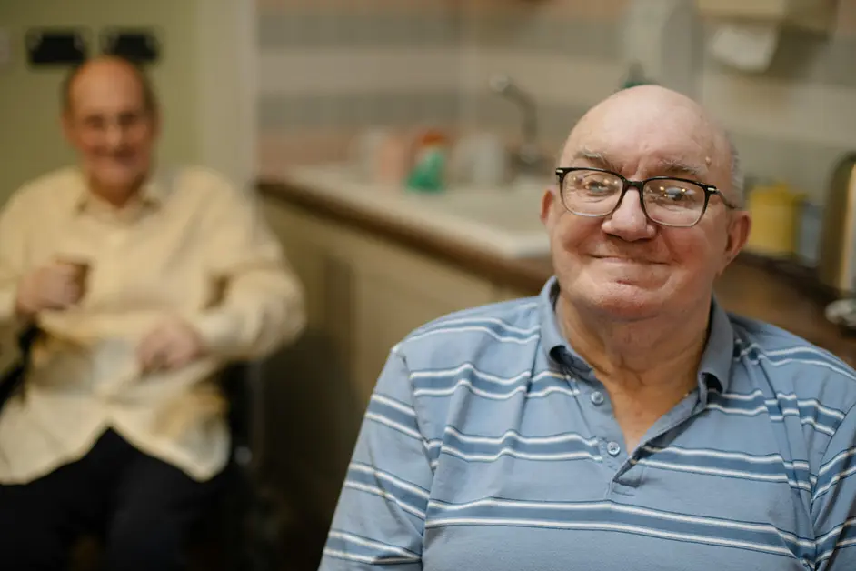 Two elderly men relaxing at home in the kitchen - home safety monitoring for independent living in Australia
